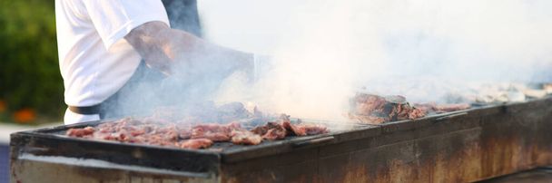 Cuisiner prépare la viande sur les charbons en plein air - Photo, image