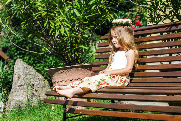 Cute litle barefoot girl sitting on the bench - Fotoğraf, Görsel