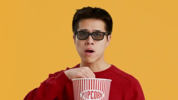 aziatische man het dragen van 3D bril kijken film eten popcorn, studio - Video