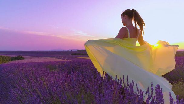 CLOSE UP: Girl in lavender field outstretches arms and lets scarf catch the wind - Photo, Image