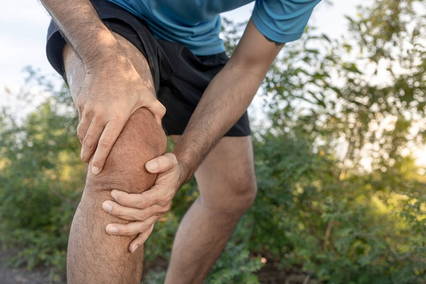 νεαρός άνδρας πόνος στο γόνατο, έννοια της υγειονομικής περίθαλψης - Φωτογραφία, εικόνα