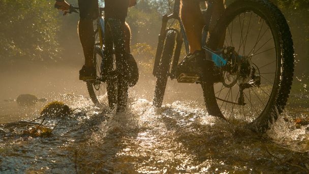 Nehir boyunca yeni dağ bisikletleri süren tanınmayan iki kişi.. - Fotoğraf, Görsel