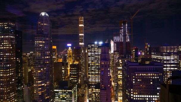ZAMKNIJ SIĘ: Zapierający dech w piersiach widok niezliczonych drapaczy chmur w Nowym Jorku oświetlonych w nocy - Zdjęcie, obraz