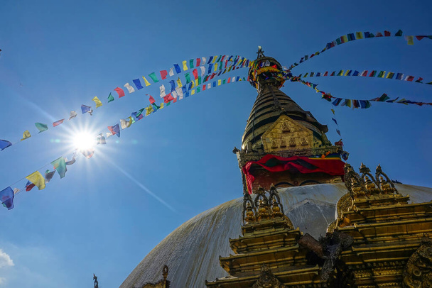 レンズフレア:カラフルな祈りの旗が風になびく仏塔の上に吹いて - 写真・画像