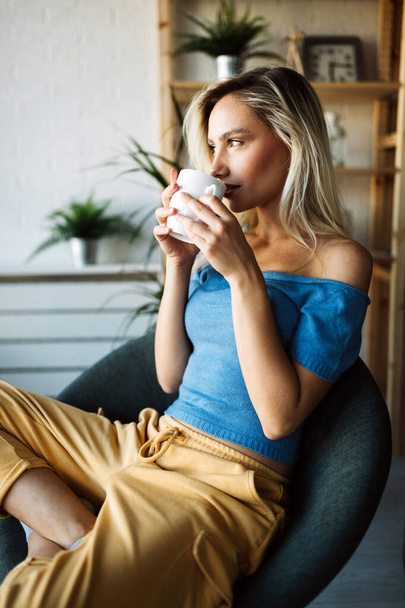 Gyönyörű fiatal nő iszik kávét, teát otthon - Fotó, kép