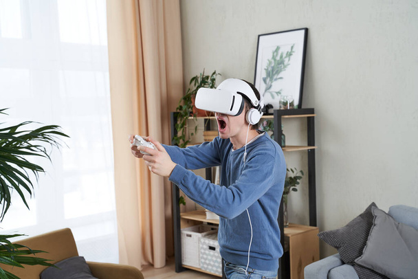 Hombre con auriculares de realidad virtual está jugando juego. - Foto, imagen