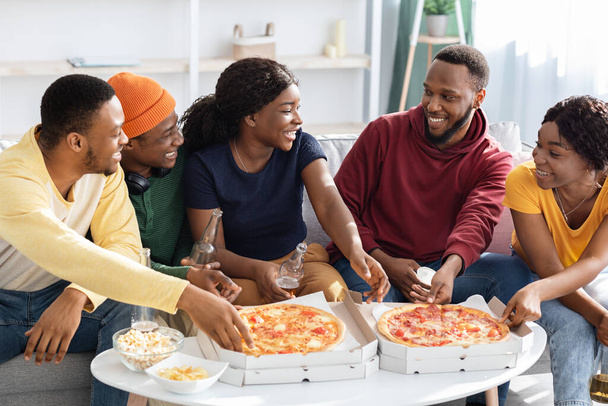 Счастливые черные миллениалы едят пиццу дома - Фото, изображение