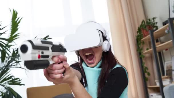 Γυναίκα παίζει παιχνίδι με τα ακουστικά εικονικής πραγματικότητας και blaster. - Πλάνα, βίντεο