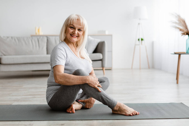 Mature woman exercising at home, posing at camera - Foto, afbeelding