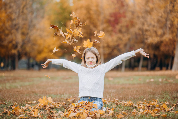 happy children play in autumn park throw up fallen leave - Fotó, kép