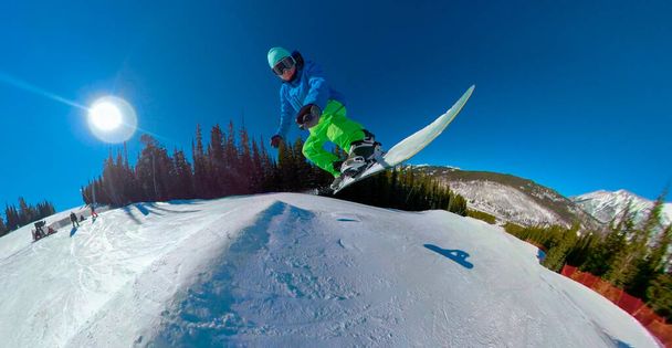 SELFIE: Extrem-Snowboarder springt an sonnigem Tag im Funpark von der Walze. - Foto, Bild