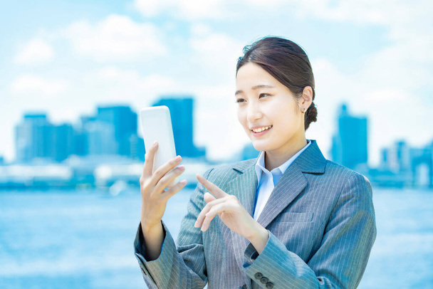 Asiatique jeune femme d'affaires opérant un smartphone - Photo, image