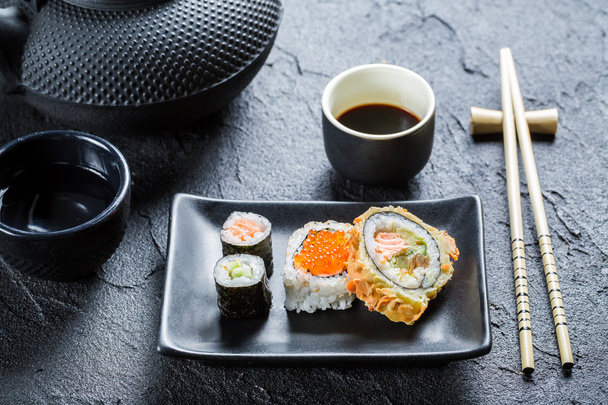 Closeup of sushi on the black ceramic dish - Photo, image