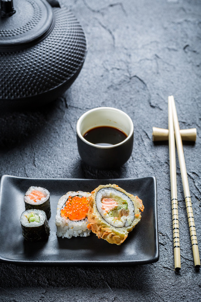 Sushi with soy sauce on the black ceramic dish - Photo, image