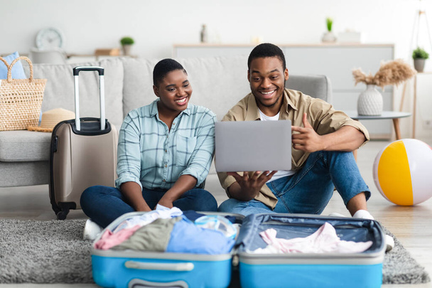 Africká americká rodina pár pomocí notebooku plánování dovolené doma - Fotografie, Obrázek