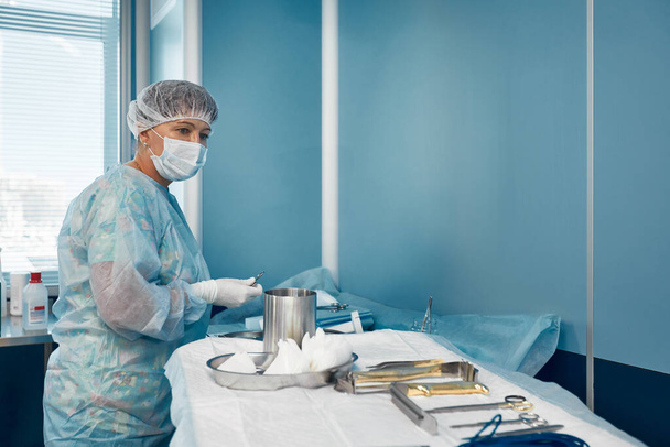 enfermeira de esfoliação preparando instrumentos médicos para a operação - Foto, Imagem