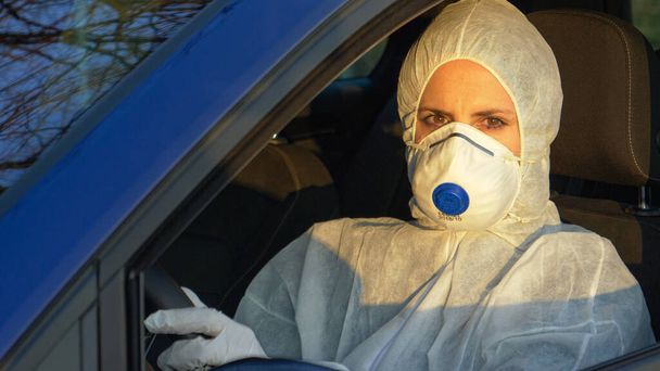 PORTRAIT: Female doctor wearing protective gear drives to coronavirus epicenter - Photo, Image