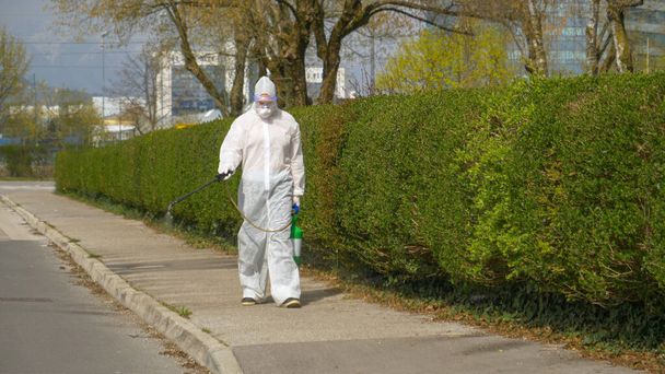 Virolog chodí po městě a postříká ulice antivirovými chemikáliemi - Fotografie, Obrázek