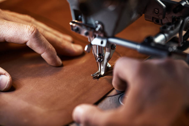 Proceso de trabajo del artesano del cuero. Tanner o skinner cose el cuero en una máquina de coser especial, cerca de costura up.worker en la máquina de coser - Foto, Imagen