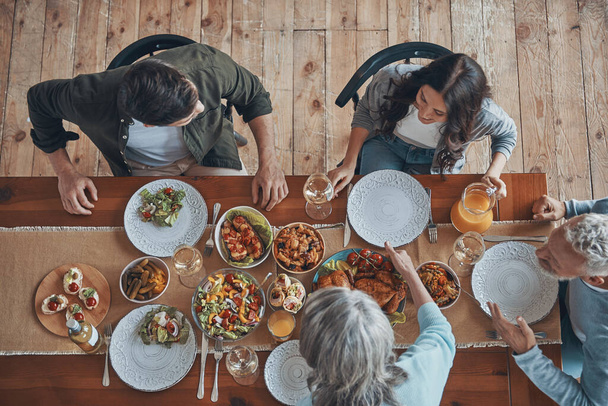 Top view of multi-generation family communicating while having dinner together - Fotó, kép