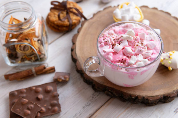 Hot drink with marshmallows on a wooden table. - Foto, afbeelding
