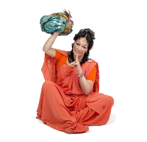 Mujer en sari naranja sentada y sujeta turbante
 - Foto, imagen