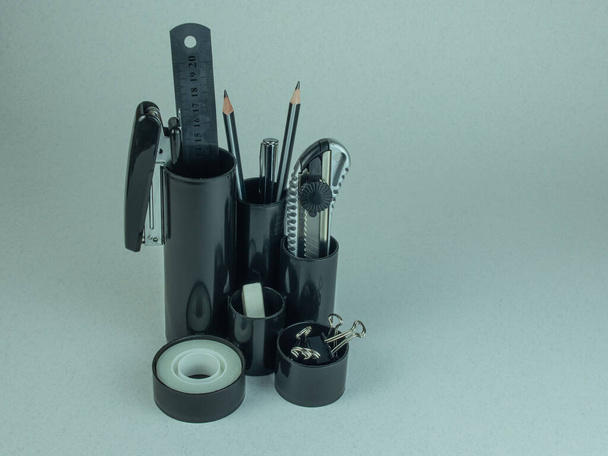Szervező állvány írószer töméssel. Tűzőgép, radír, szalag, ceruza, toll, írószer kés, kötőanyagok, mérőléc. - Fotó, kép
