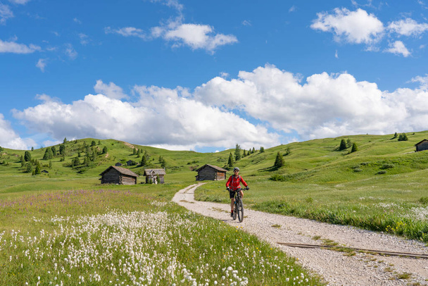 melko aktiivinen vanhempi nainen ratsastus hänen sähköinen maastopyörä Pralongia Plateau Alta Badia Dolomites mahtava Sasso die Santa Cruce huippukokouksessa Backg, Etelä-Tirol ja Trentino, Italia - Valokuva, kuva