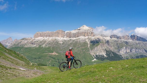  bella donna anziana attiva cavalcando il famoso Sella Ronda Mountain Bike Trail nel gruppo montuoso del Sella, Dolomiti di Selva Wolkenstein, Val Gardena, Alto Adige e Trentino - Foto, immagini