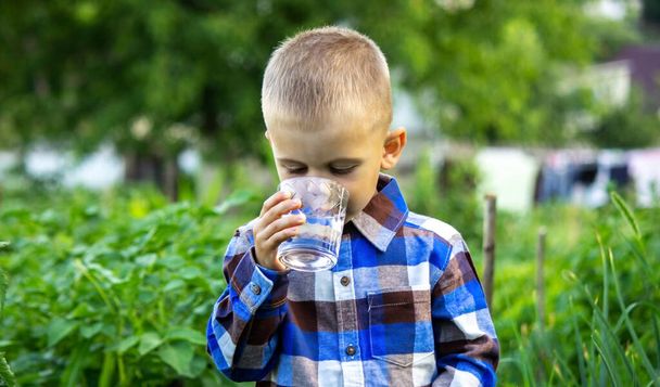 Çocuk doğada temiz su içer. Seçici odak - Fotoğraf, Görsel