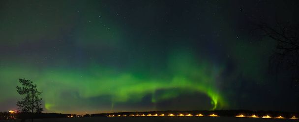 Multibarevné panorama Aurora borealis na hvězdné noční obloze nad městem. Aurora Borealis nad Švédskými jezerními ostrovy. Severní Švédsko. Zimní hvězdná obloha. - Fotografie, Obrázek