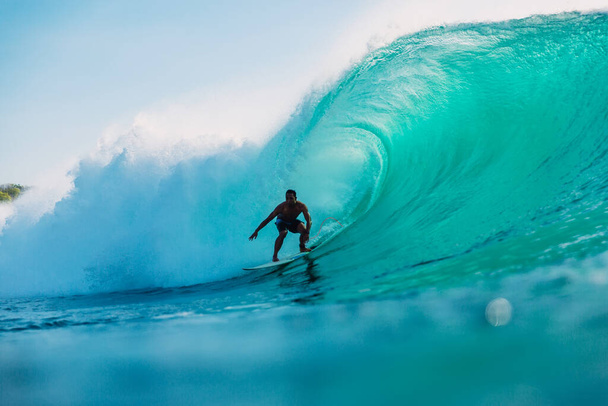12. Mai 2021. Bali, Indonesien. Surfer reiten auf Surfbrett bei Fasswelle. - Foto, Bild