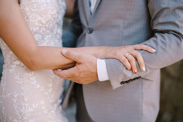 Der Bräutigam hält den Arm der Braut. Nahaufnahme - Foto, Bild
