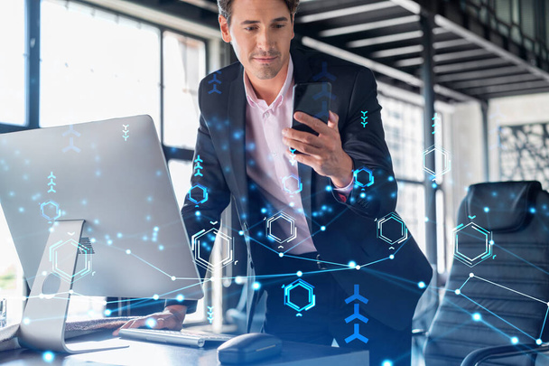 Businessman in suit using smart phone to optimize development by implying new technologies in business process. Interconnections and hi tech hologram over modern panoramic office background. - Photo, Image