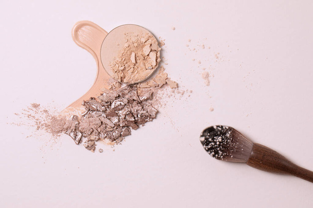 Crashed beige face finishing and liquid powder and zero waste wood finishing powder brush. Macro texture of make-up on beige background - Zdjęcie, obraz