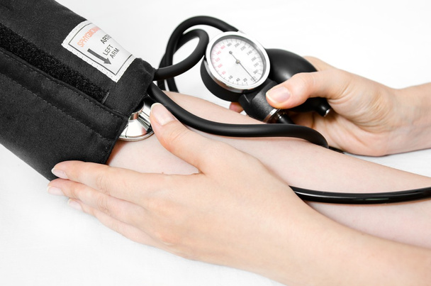 arts gebruikt een bloeddrukmeter  - Foto, afbeelding
