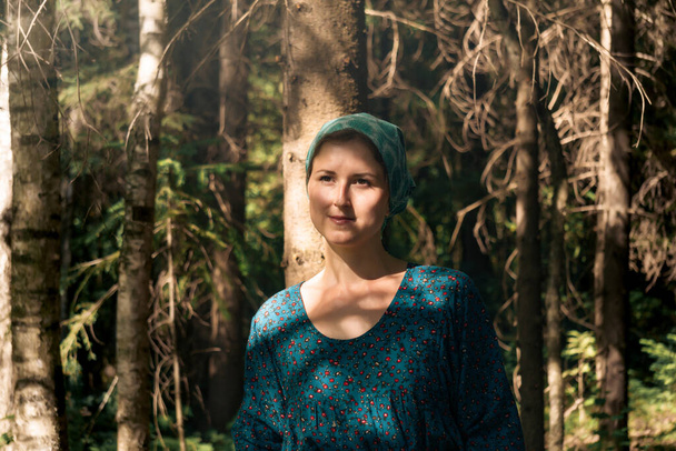 Porträt einer jungen Frau in volkstümlicher Bauerntracht im Nadelwald - Foto, Bild