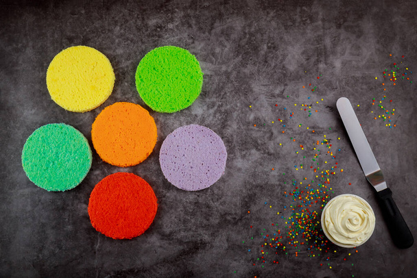 Hacer pastel de capa de arco iris con crema blanca y espátula. - Foto, Imagen