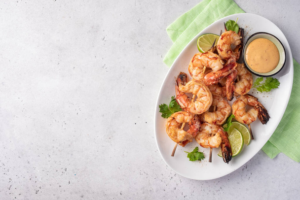 Grilled shrimps. Shrimps skewers, lime and fresh herbs - Foto, imagen