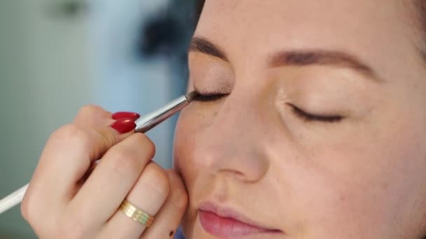 women do make-up, paint the eyelids on the eyes with a makeup brush.  - Felvétel, videó