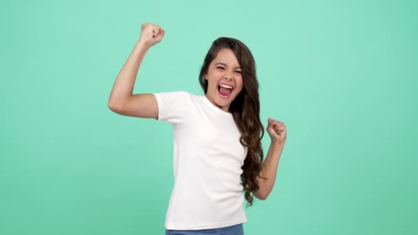 Porträt eines extrem glücklichen Teenie-Mädchens mit langen lockigen Haaren, das Freude und Sieg empfindet - Filmmaterial, Video