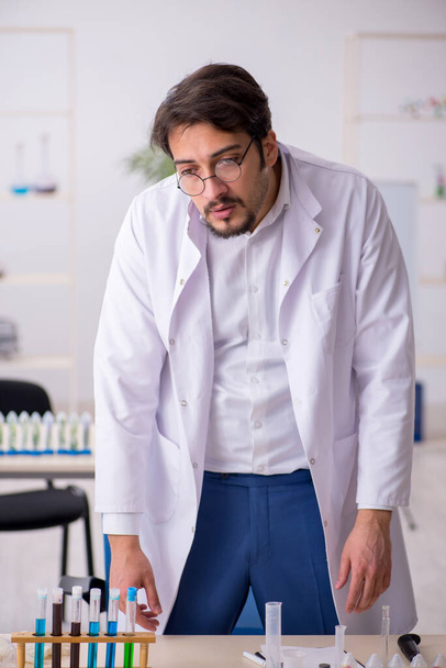 Νεαρός άντρας χημικός σε σύνθεση φαρμάκων - Φωτογραφία, εικόνα