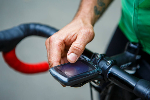 Usando el odómetro de la computadora de la bicicleta en el volante en el fondo del ciclista, tiro del punto de vista - Foto, Imagen