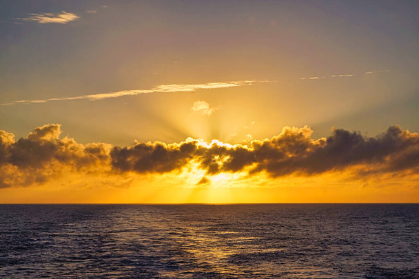 Το φως του ήλιου εμφανιζόταν και εξαφανιζόταν από καιρό σε καιρό ανάμεσα στα σύννεφα. Η ομίχλη είναι πολύ θεαματική. Το ηλιοβασίλεμα από το σκάφος. Βόρειος Ειρηνικός Ωκεανός, Ιούνιος, 2019. - Φωτογραφία, εικόνα