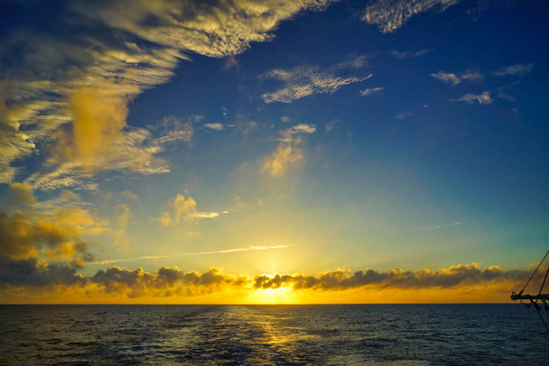 Mezi mraky se čas od času objevovalo a mizelo sluneční světlo. Ten opar je velmi velkolepý. Západ slunce z lodi. Severní Tichý oceán, červen 2019. - Fotografie, Obrázek