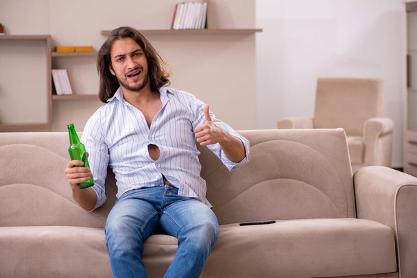 Young man drinking alcohol at home - Photo, Image