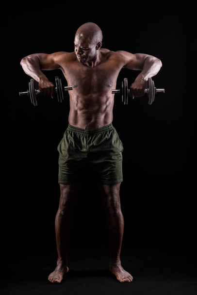 Widok z przodu muskularny mężczyzna stojący robi triceps ćwiczenia  - Zdjęcie, obraz
