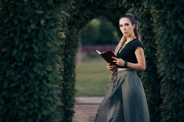 Woman Wearing Ethnic Outfit Reading a Book in the Garden - Foto, Imagen