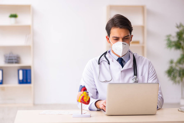 Jeune médecin cardiologue travaillant à la clinique pendant pand - Photo, image