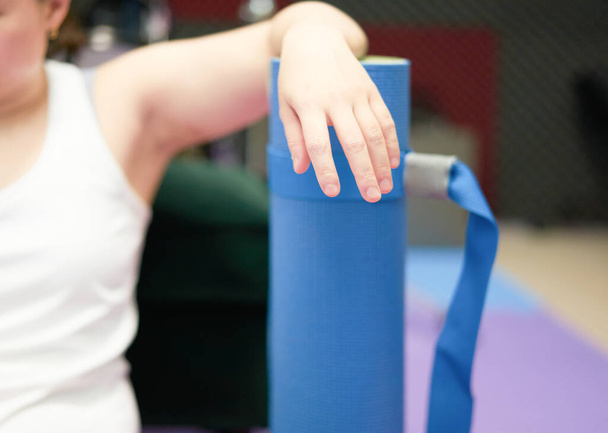 ręka i ramię na rozmytej rolce maty do jogi po treningu w domu - Zdjęcie, obraz